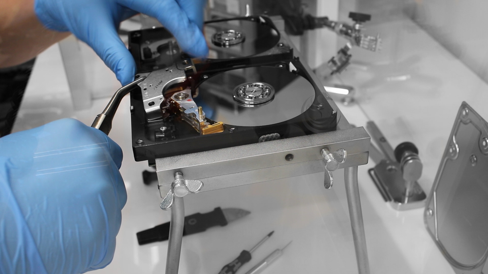 Data Recovery engineer Dragon Data Recovery engineer working on an open hard drive with a head-replacement tool in the lab cleanroom station